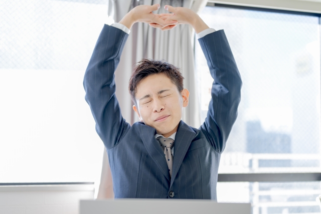 alt="派遣求人が落ち着いて背伸びする男性”