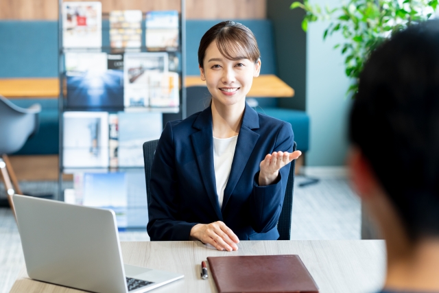 alt="派遣事務の仕事内容を未経験の男性に説明している”